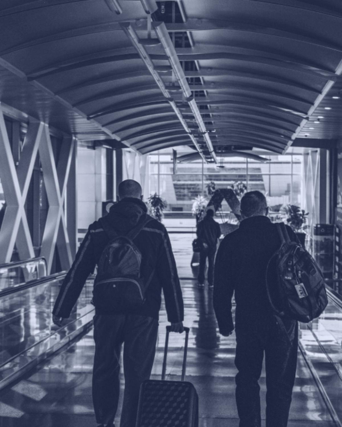 Due persone con i bagagli lungo il corridoio di un aeroporto